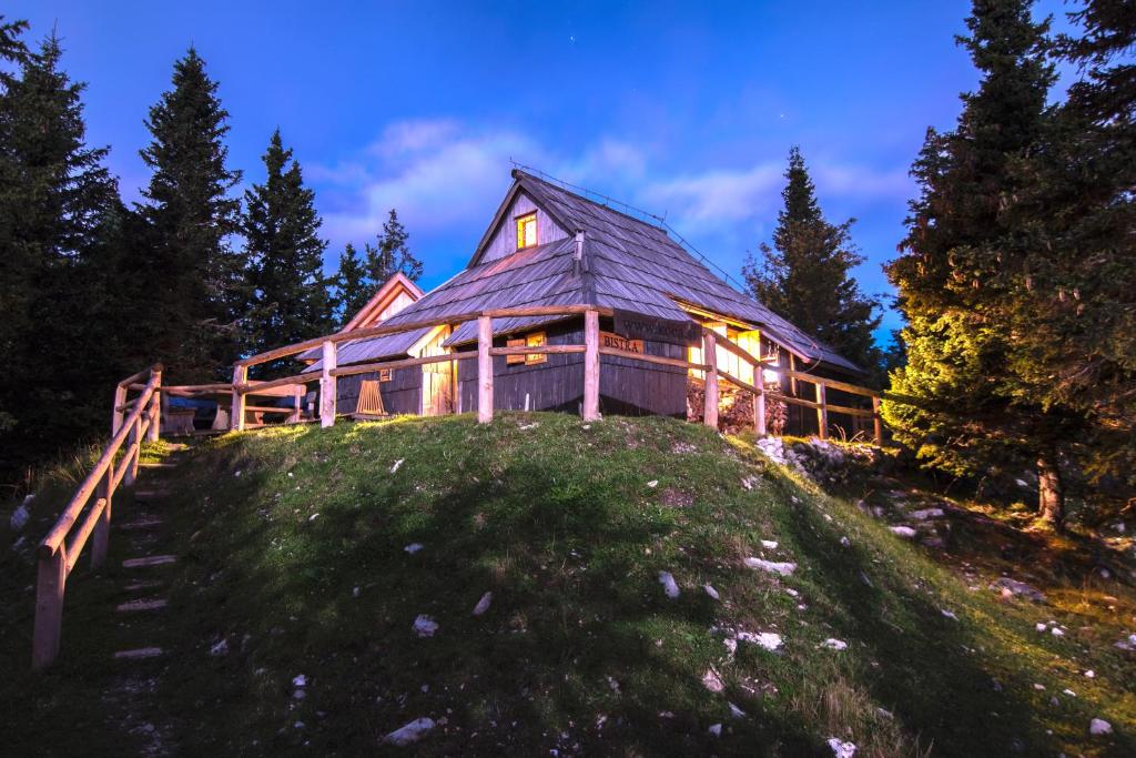 une grande maison en bois au sommet d'une colline dans l'établissement Koča Bistra - Velika planina, à Stahovica