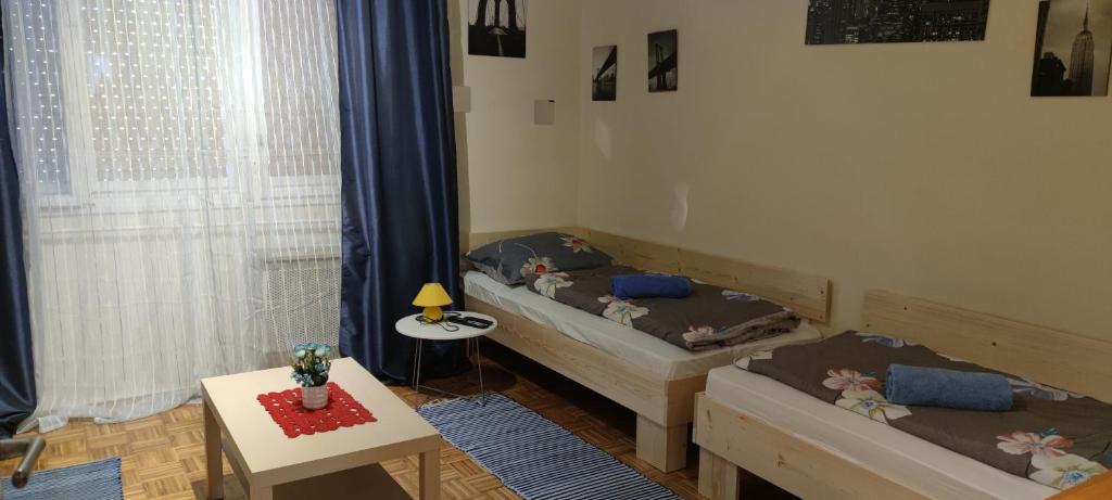 2 camas en una habitación pequeña con mesa y mesa en Orsi Szálláshelyek Kecskemét 2, en Kecskemét