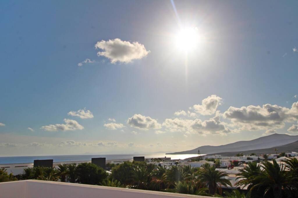 a view of the beach with the sun in the sky at Casa Esperanza, 2 Bedroom Duplex Puerto Calero in Puerto Calero