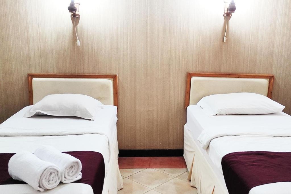 Postel nebo postele na pokoji v ubytování Hotel Salma Syariah Mitra RedDoorz near Terminal Baru Kediri
