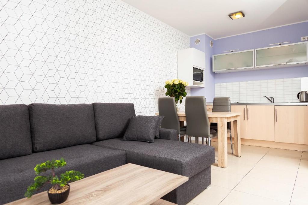 a living room with a couch and a table at Apartament Maxim in Darłówko