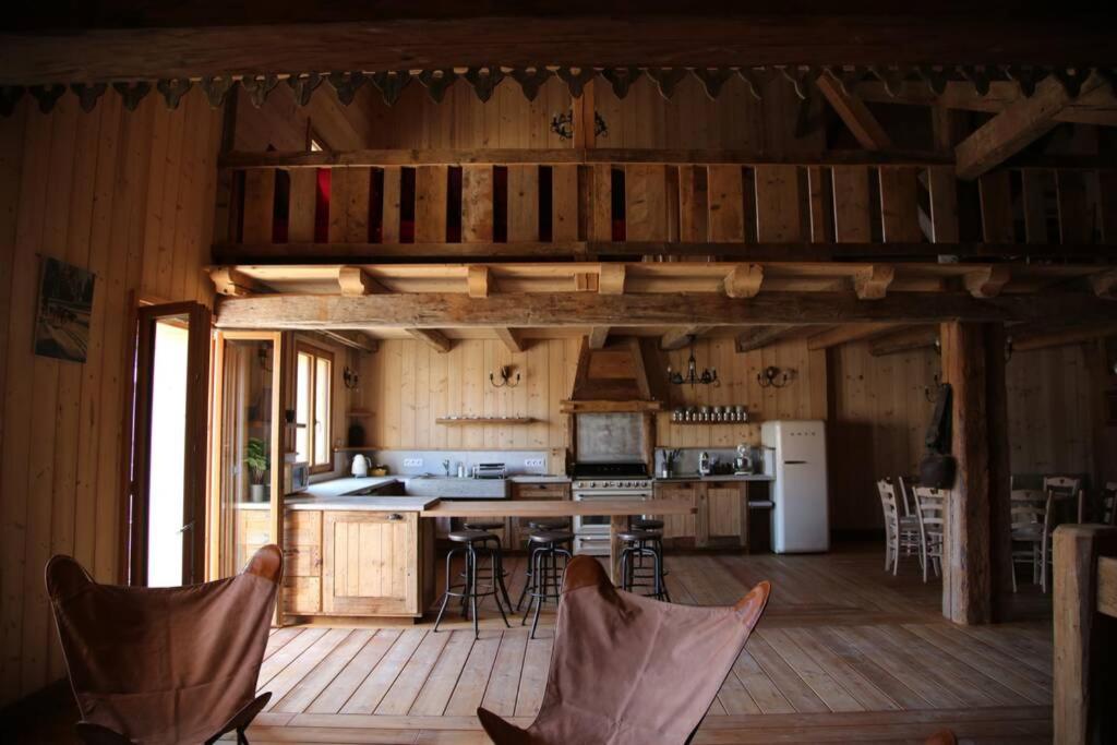a kitchen with a table and chairs in a cabin at La Grande Marguerite in Les Fourgs