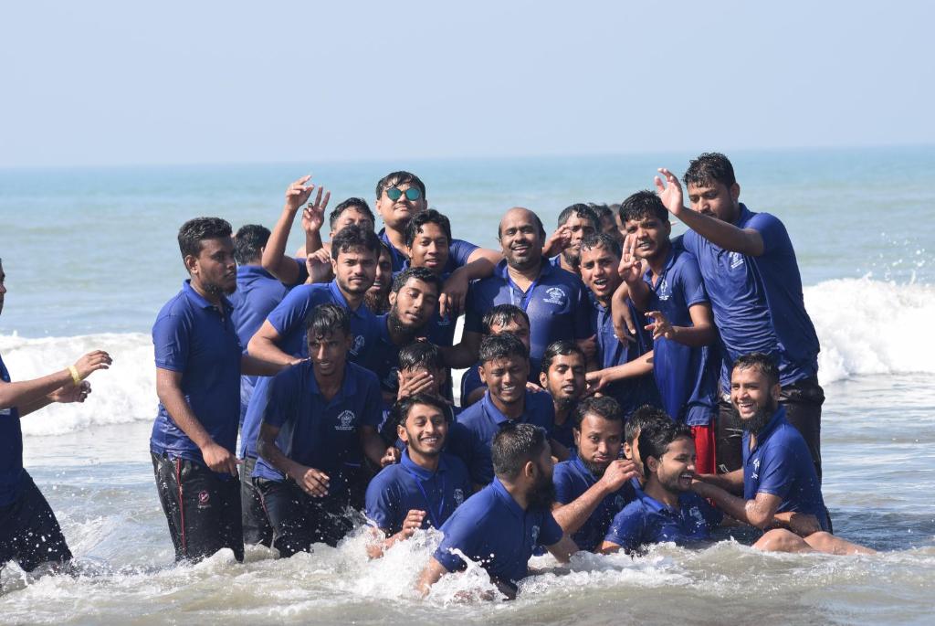 a group of men posing for a picture in the ocean at 2BHK Stunning Apartment with Pool in Vagator