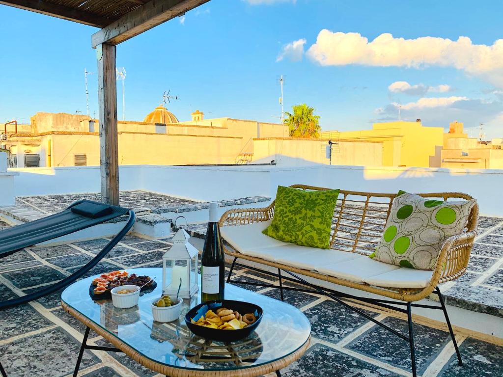 une terrasse avec une chaise et une table avec une bouteille de vin dans l'établissement Il Palazzo dei Venti, à Neviano