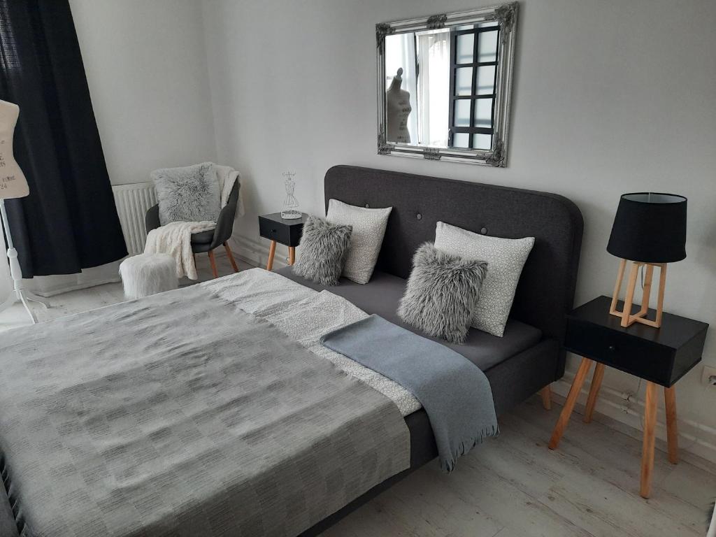 a bedroom with a bed and a couch and a mirror at Downtown's pearl in Pécs
