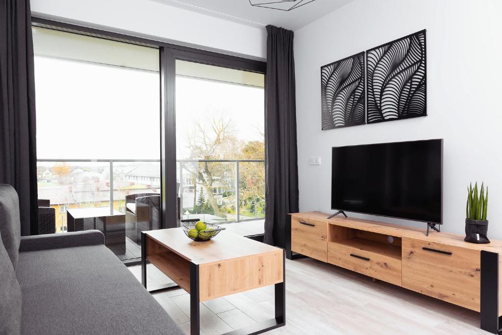 a living room with a tv and a couch at Apartament Maxim Premium in Darłowo