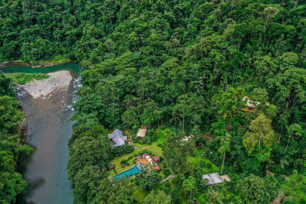 an aerial view of a house in the forest next to a river at Pacuare Lodge by Böëna in Bajo Tigre