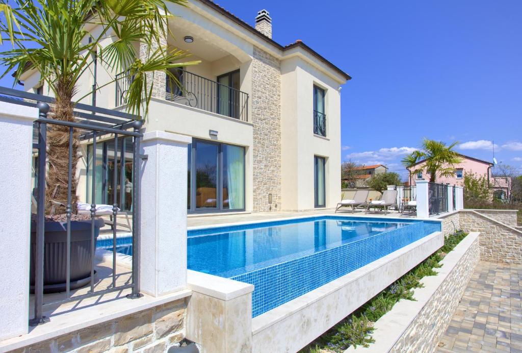 a villa with a swimming pool in front of a house at Villa Allegra in Krk
