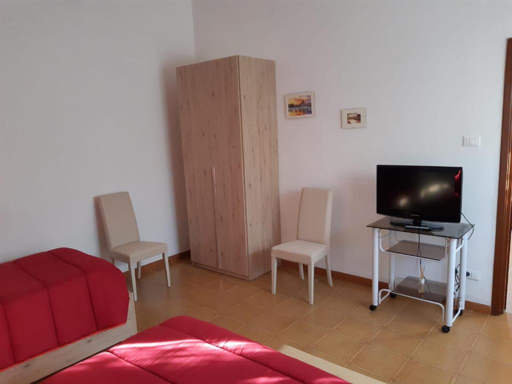 een woonkamer met een tv en een tafel en stoelen bij Small Flat in Scafa