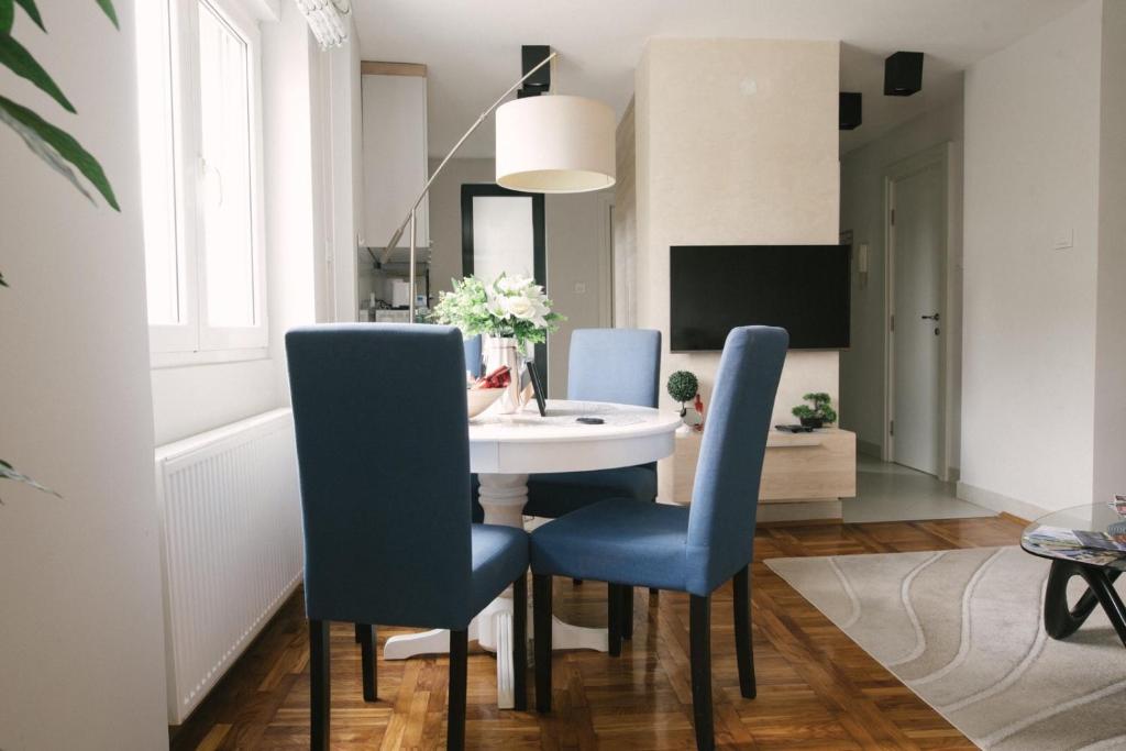 jadalnia z białym stołem i niebieskimi krzesłami w obiekcie Apartman Marina Subotica w mieście Subotica