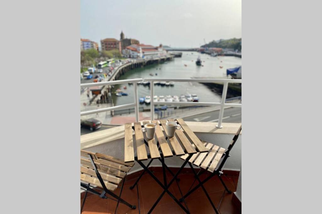 un par de bancos sentados en un balcón junto a un río en Vivienda con impresionantes vistas/apartamento Artza en Bermeo