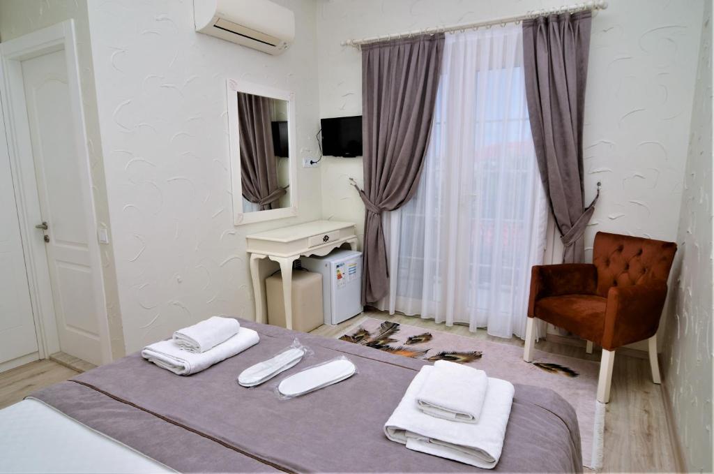 A bed or beds in a room at Alacati Eldoris Butik Hotel