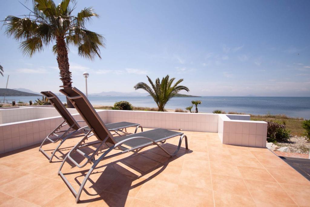 two chairs on a patio with the ocean in the background at Soling 65 in La Manga del Mar Menor