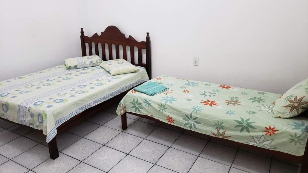 duas camas sentadas uma ao lado da outra num quarto em Suítes em Parintins em Parintins