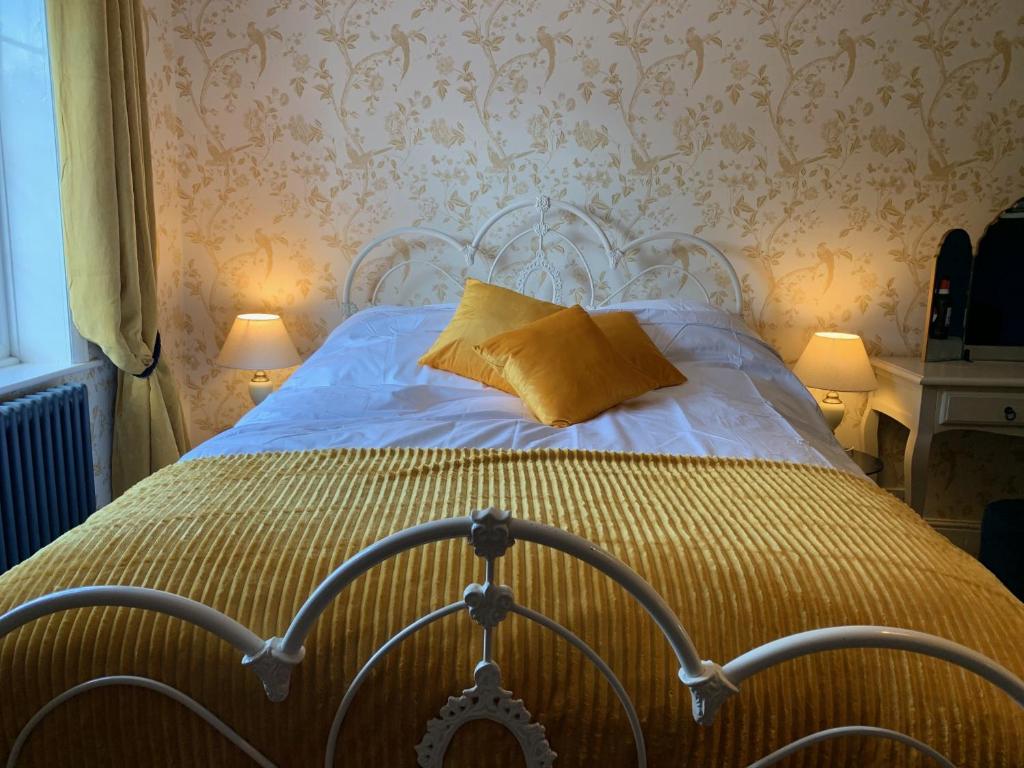 um quarto com uma cama com uma almofada amarela em Seven Stars Boutique Guesthouse em Exeter