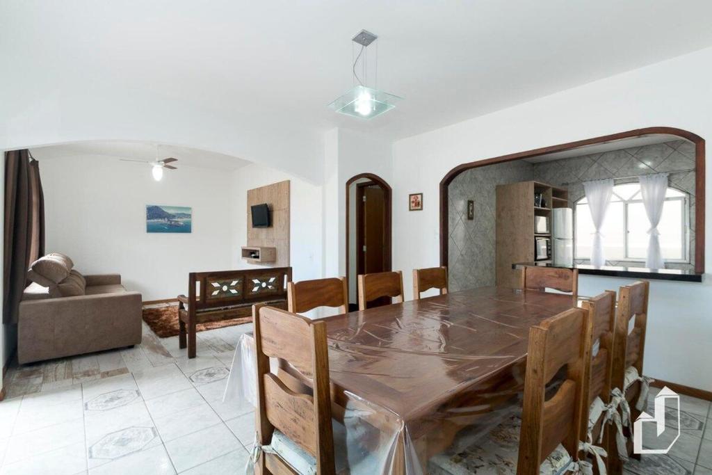 - une salle à manger et un salon avec une table et des chaises dans l'établissement Casa com 03 dormitórios, à Bombinhas