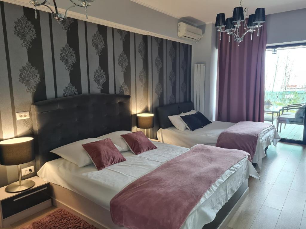 two beds in a bedroom with purple walls at Blue Bike Studio in Mamaia