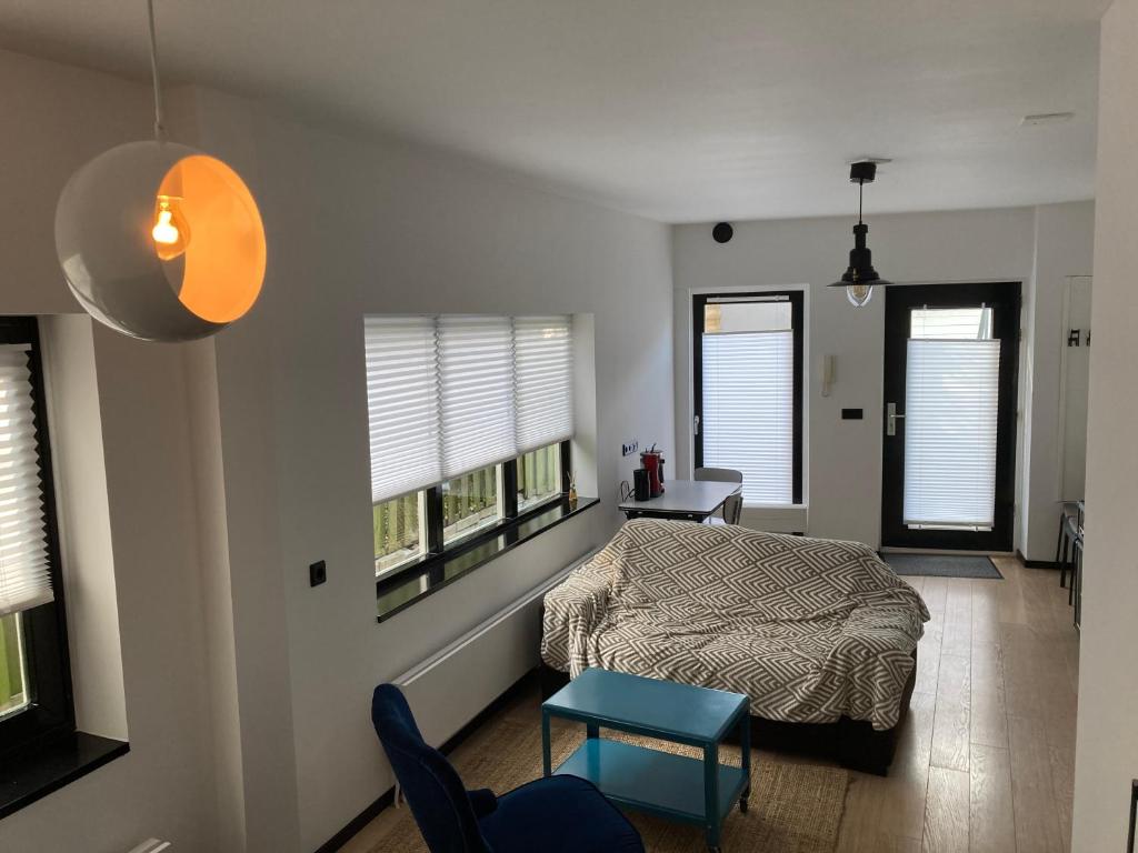 een slaapkamer met een bed, een tafel en 2 ramen bij Sheepyhead in Dordrecht