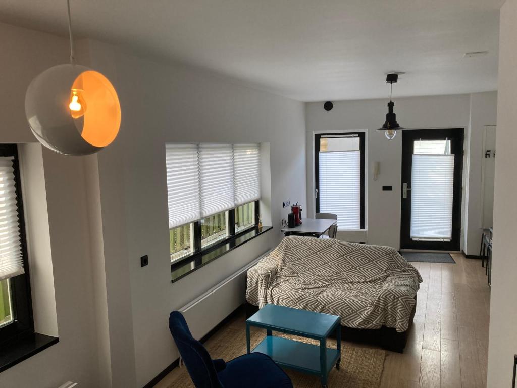 een slaapkamer met een bed en een tafel en twee ramen bij Sheepyhead in Dordrecht