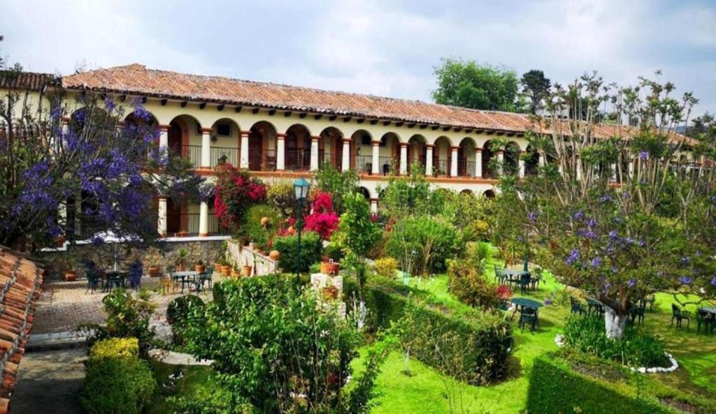 ein Gebäude mit einem Garten davor in der Unterkunft Hotel Rincon Del Arco in San Cristóbal de las Casas