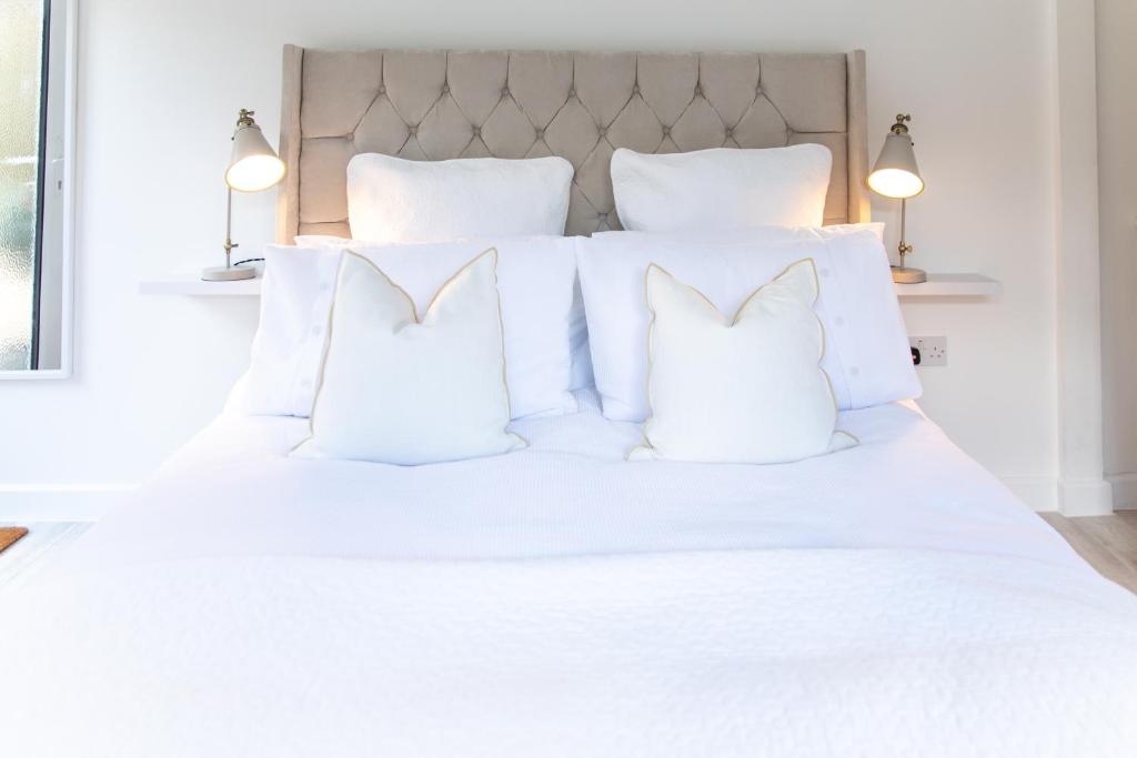 a white bed with white pillows on it at The Nook in West Mersea