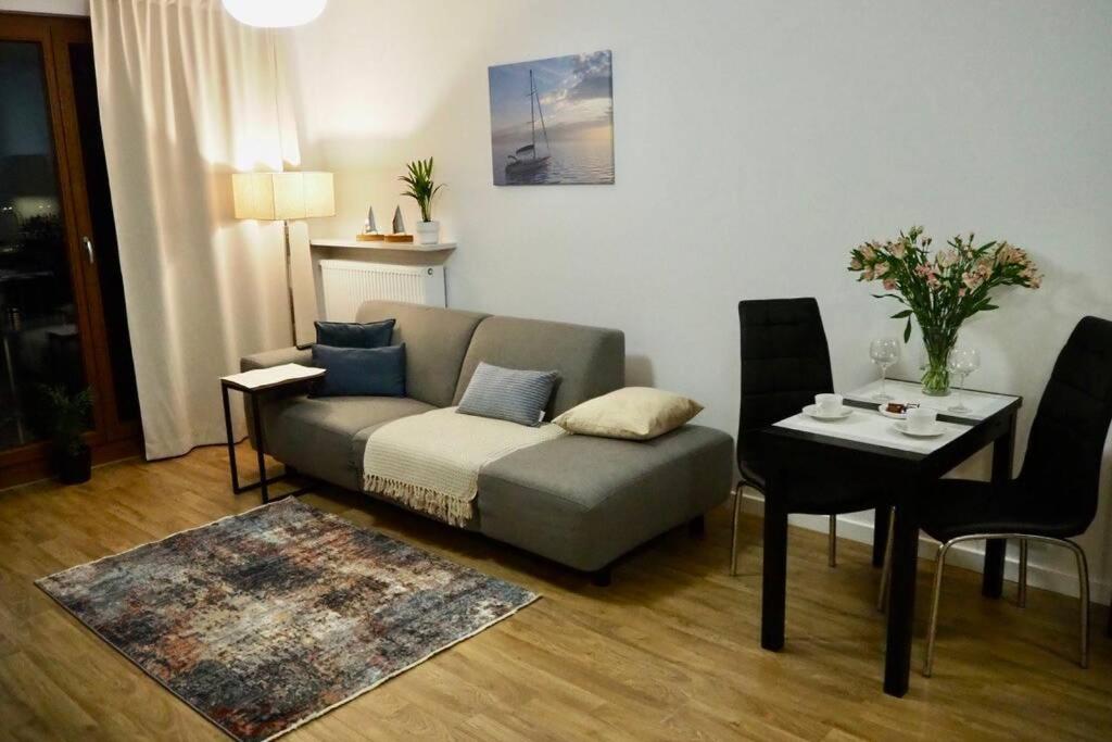 uma sala de estar com um sofá e uma mesa em Sunny apartment in Wilanów close Town Hall, Palace em Varsóvia
