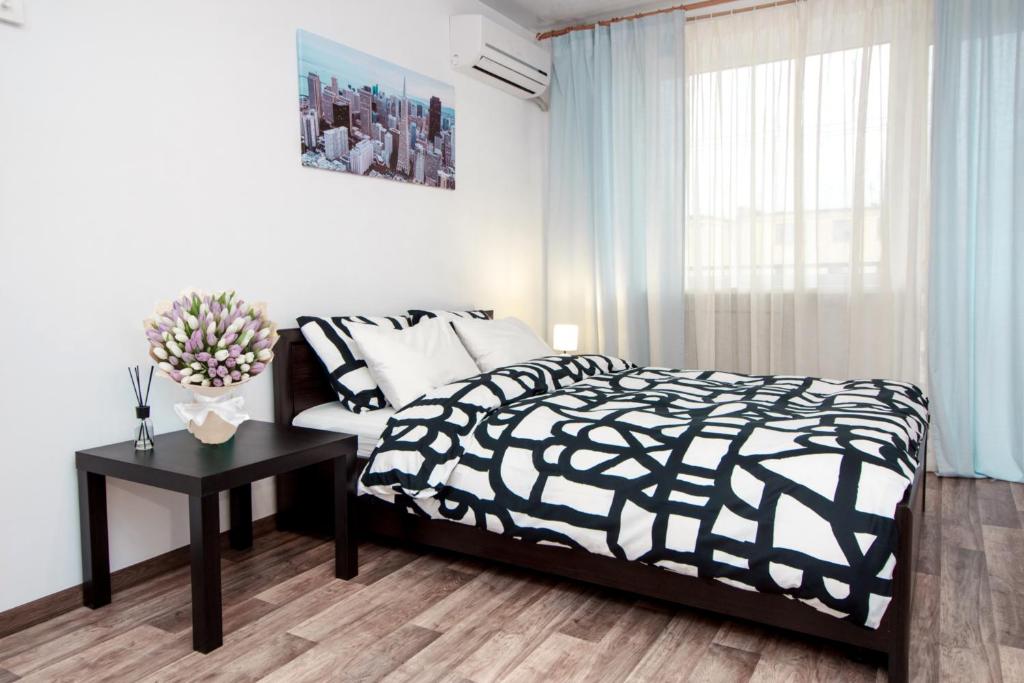 a bedroom with a black and white bed and a table at Apartment on Soborniy 85 in Oleksandriya