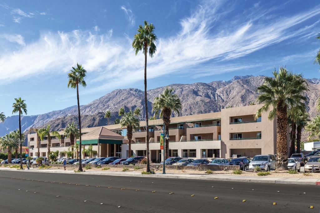 a hotel with palm trees and mountains in the background at WorldMark Palm Springs in Palm Springs
