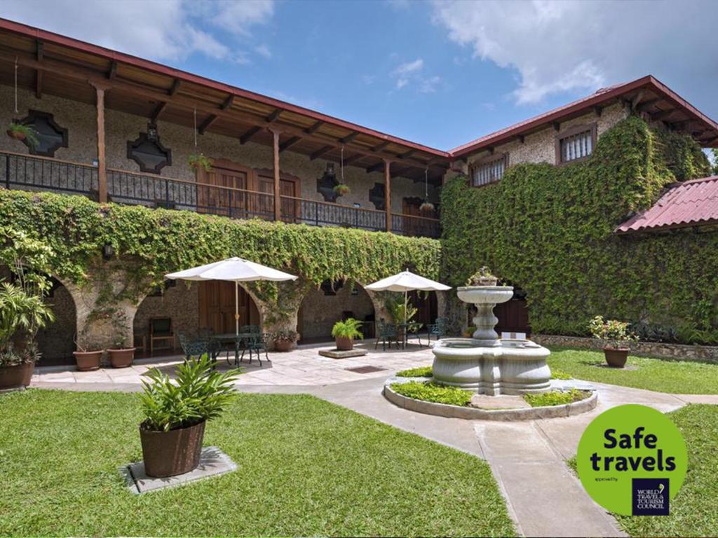 a building with a fountain in front of it at Hotel del Patio in Flores