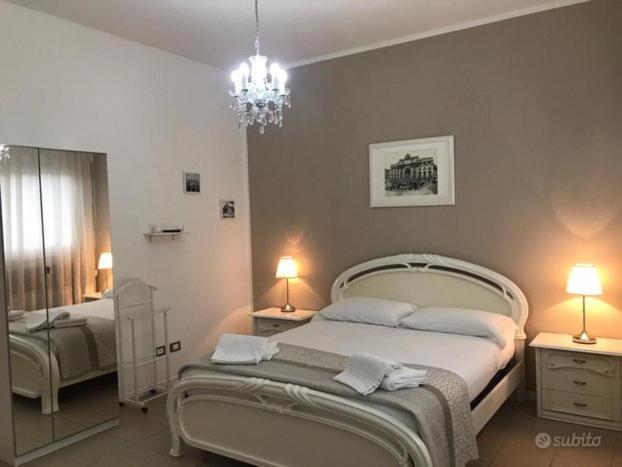 a bedroom with two beds and a chandelier at San Donato Apartment in Turin