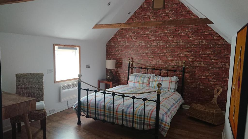 - une chambre avec un lit et un mur en briques dans l'établissement BexLet, à Bexhill-on-Sea