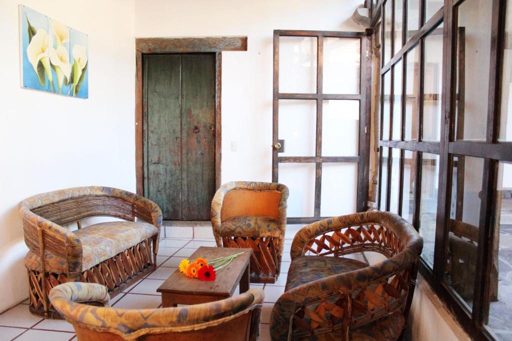 a living room with wicker chairs and a table at Las Margaritas Hotel Posada in Tapalpa
