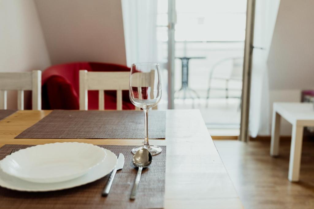 un tavolo con un piatto e un bicchiere di vino di Apartament 4 Żagle a Giżycko