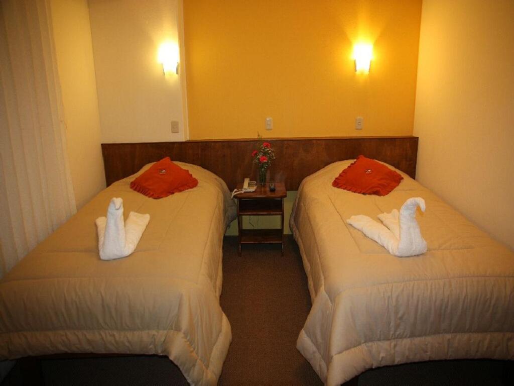 Un pat sau paturi într-o cameră la Hotel Munay Tambo