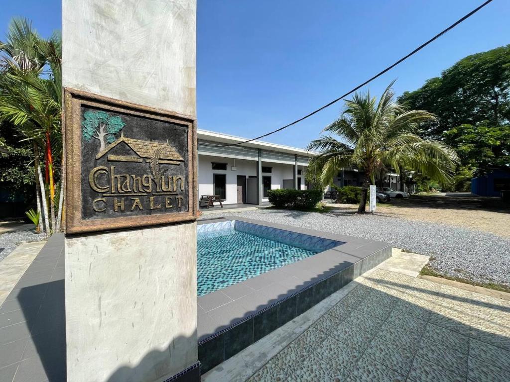 a building with a swimming pool in front of a building at Changlun Chalet in Changlun