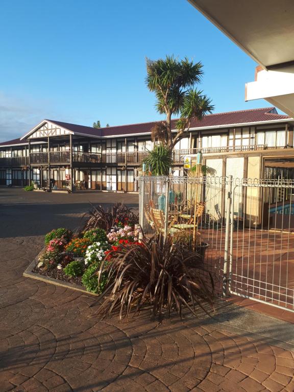 una recinzione di fronte a un edificio con fiori di Albatross Motel a Napier