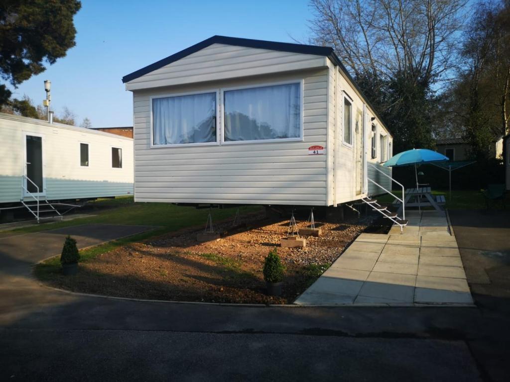 a tiny house sitting on the side of a driveway at 41 Orchard Bank, 3 bed, Rockley Park Poole in Poole