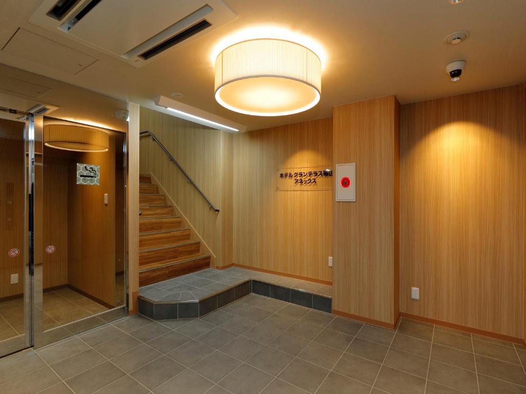 a hallway with a staircase and a light at Hotel Grand Terrace Obihiro Annex in Obihiro