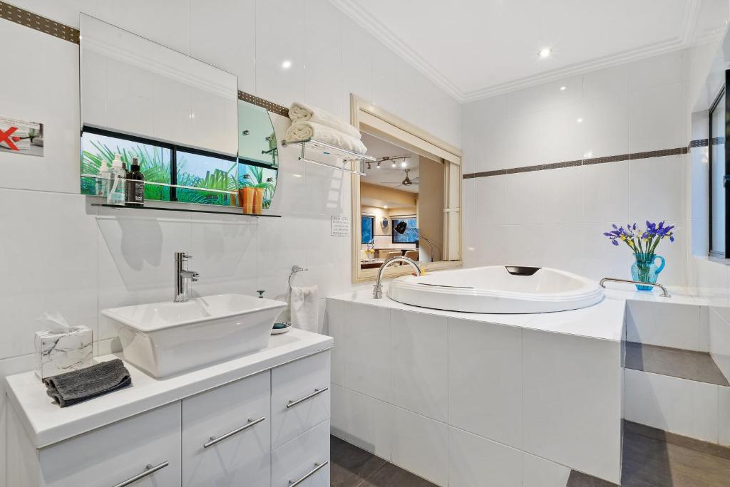 a white bathroom with a sink and a mirror at About Time Retreats- Studio Seven in Mansfield