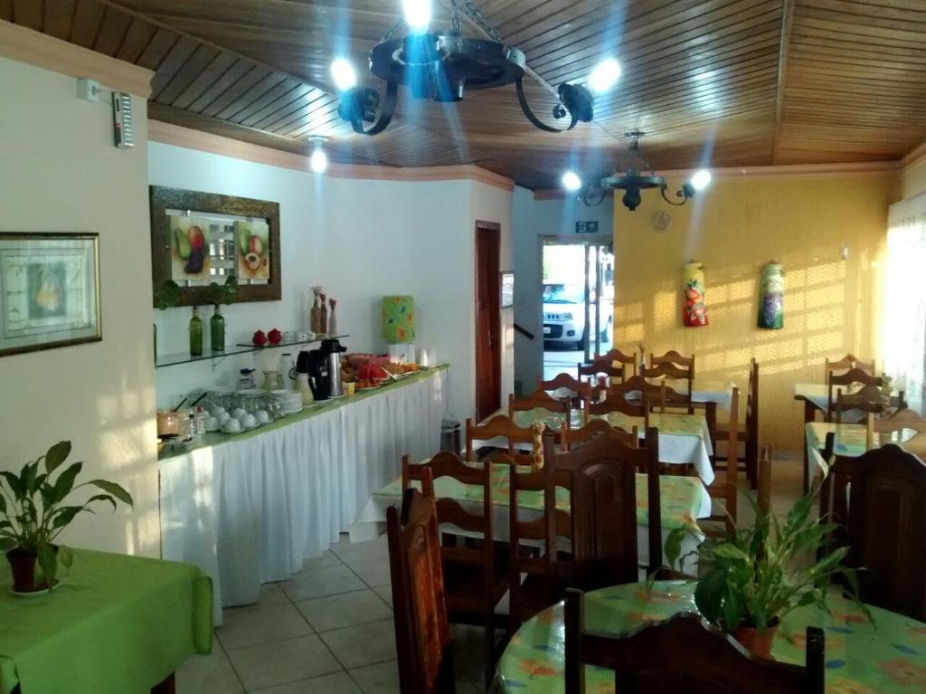 uma sala de jantar com mesas e cadeiras num restaurante em Aconchego Canastra Hotel em Vargem Bonita