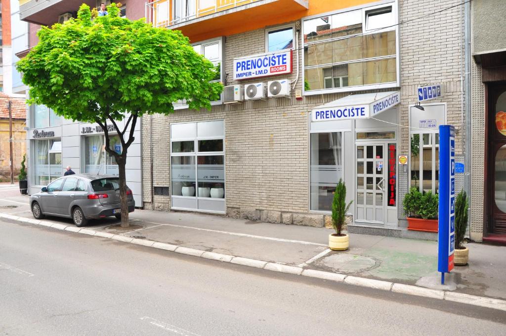 un coche aparcado frente a un edificio en una calle en Apartments Imper - IMD, en Niš