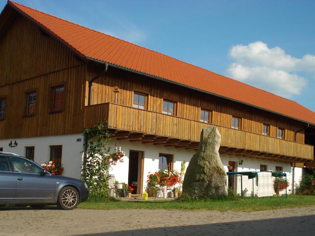 a large wooden building with a car parked in front of it at Bärenhof in Tirschenreuth