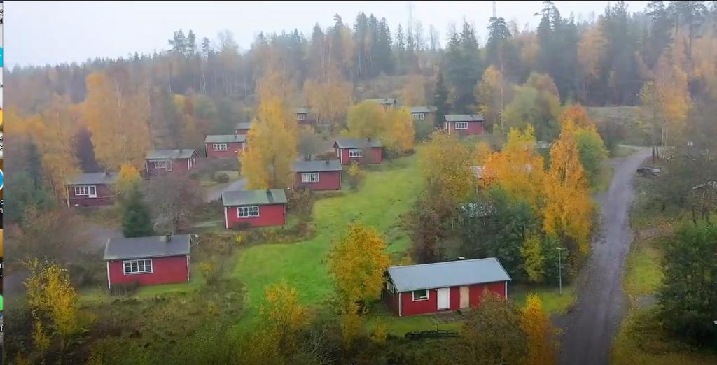 a group of houses on a hill with trees at Three Rooms stuga i stugby near National Park in Undenäs