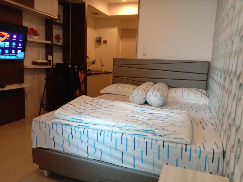 a bedroom with a bed with blue and white sheets at bintang room in Bekasi