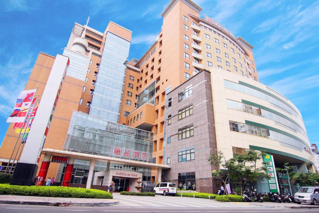 a tall building with cars parked in front of it at Chateau de Chine Xinzhuang in Xinzhuang