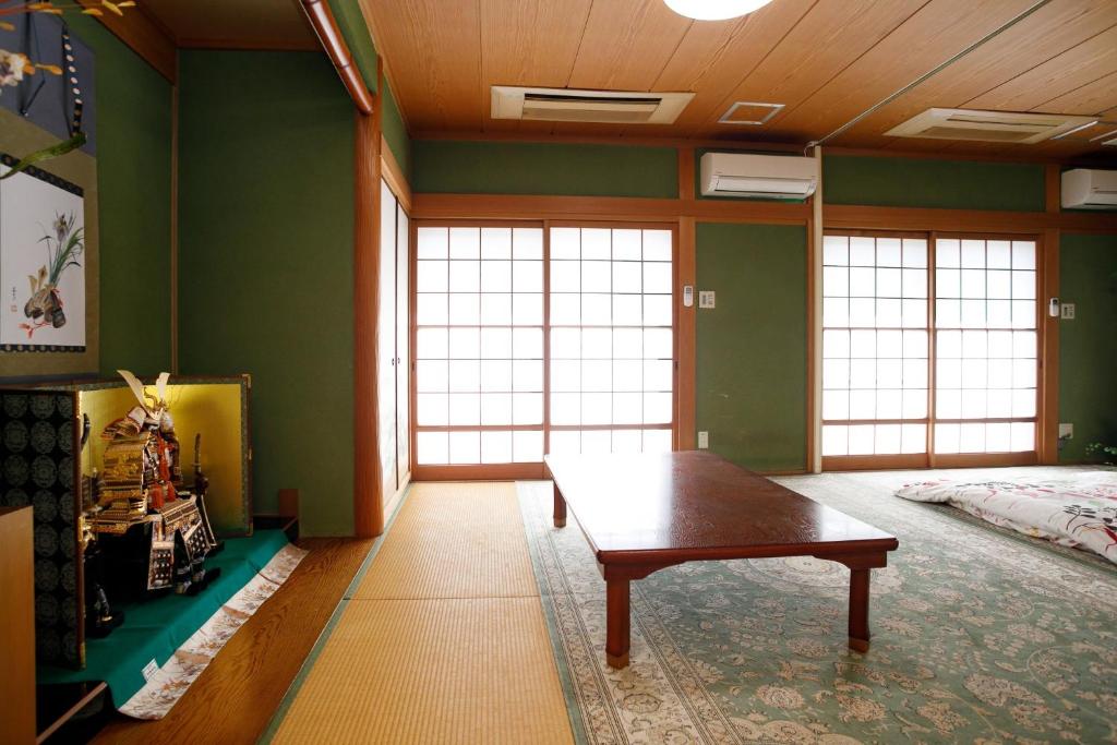 um quarto com uma mesa num quarto com paredes verdes em Gairoju / Vacation STAY 3715 em Higashi-osaka