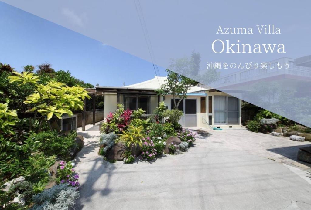 a house with a garden with flowers in front of it at Kume Azuma Villa in Kumejima
