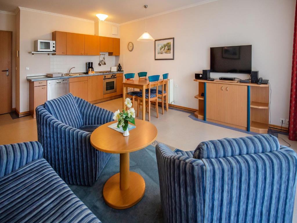 Una sala de estar con dos sillas azules y una mesa. en Dünenpark Binz - Klassik Ferienwohnung mit 1 Schlafzimmer und Balkon im Obergeschoss 018, en Binz
