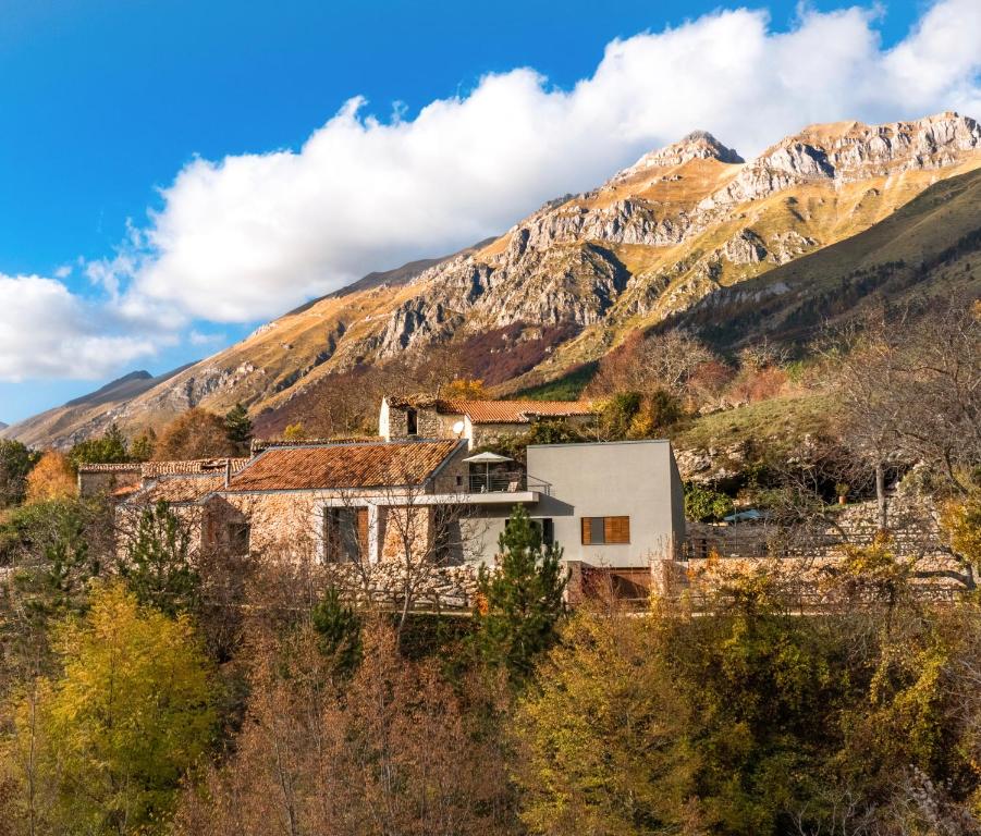 una vecchia casa di fronte a una montagna di Rifugio del Gran Sasso ad Assergi