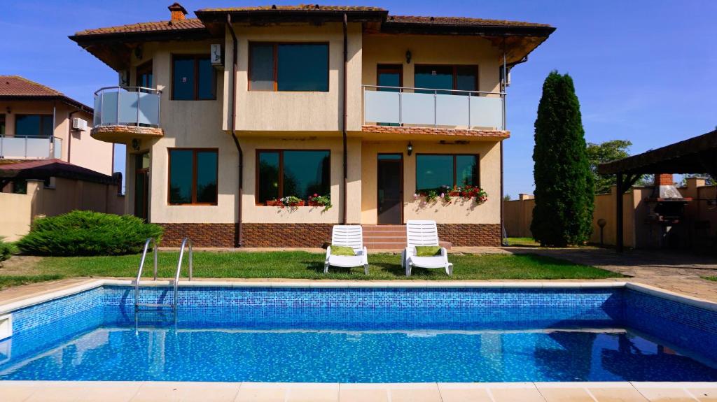 a house with a swimming pool in front of a house at Вила Ваня - Villa Vania in Bŭlgarevo